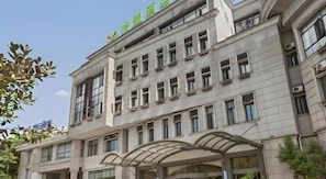 A multi-story building with a covered entrance and a sign indicating it is a hotel. - GreenTree Alliance Hotel (Shanghai Baoshan District Meilan Lake Yueluo Road) (Shanghai)