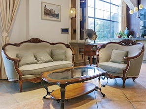 A room with two upholstered sofas, a glass-top coffee table, and a decorative lamp. - GreenTree Alliance Hotel (Shanghai Baoshan District Meilan Lake Yueluo Road) (Shanghai)
