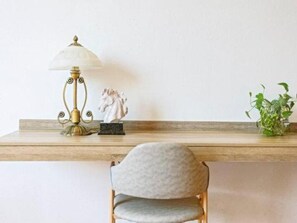 A desk with a lamp, a small statue, and a plant. - GreenTree Alliance Hotel (Shanghai Baoshan District Meilan Lake Yueluo Road) (Shanghai)