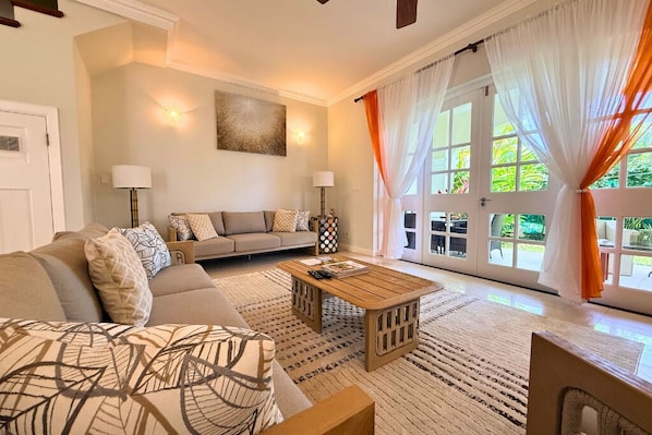 A living room with a sofa, a coffee table, and a door leading to a balcony.