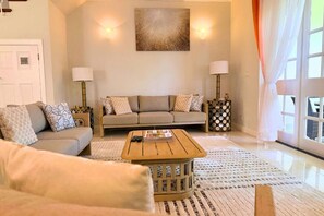 Un salon avec un canapé, une table basse et des lampes.