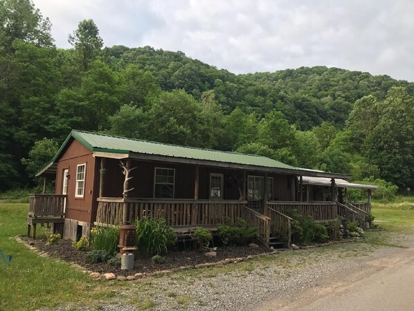 A rustic cabin with a green roof, wooden deck, and a porch. - Pioneer cabin in Bowden, Canaan Valley sleeps 8 (Elkins)