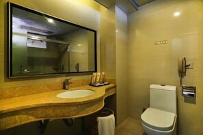 Un baño con un espejo grande, un lavabo, un inodoro y un perchero para toallas.