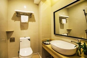 A bathroom with a toilet, sink, and mirror. - Yilan Hotel (Wuyishan)