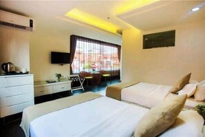 Una habitación de hotel con dos camas, un escritorio, una silla y un televisor.