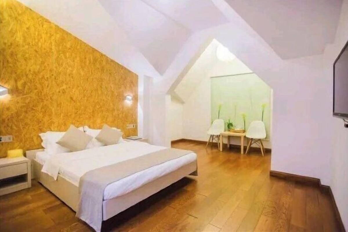 Un dormitorio con una pared de acento de madera, una cama, un escritorio y una silla.