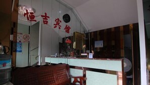 A reception area with a wooden bench, a counter, and a clock on the wall. - Hengji Hotel (Shanghai Hongkou Football Stadium Dongbaoxing Road Subway Station) (Shanghai)