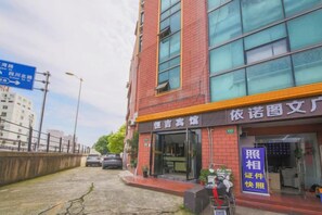 A building with a storefront, a signboard, and a clear sky. - Hengji Hotel (Shanghai Hongkou Football Stadium Dongbaoxing Road Subway Station) (Shanghai)
