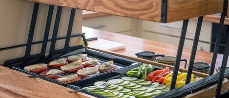 A buffet with various food items including sliced vegetables and meats.