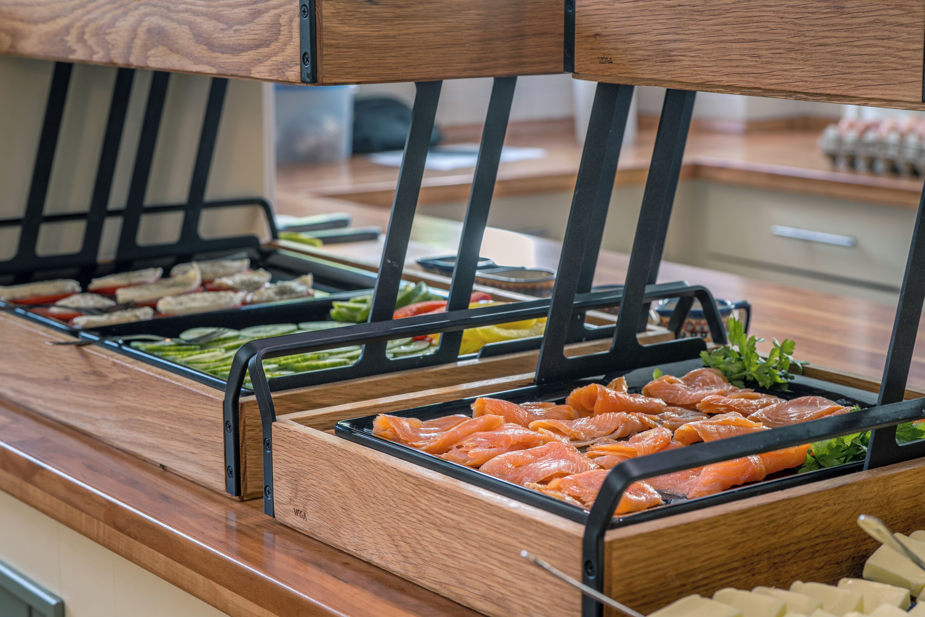 Ein Buffet mit verschiedenen Speisen, darunter Lachs und Gemüse.