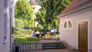 A courtyard with steps leading to a building entrance, benches, and a small garden area. - Hotel Zum Hothertor (Görlitz)