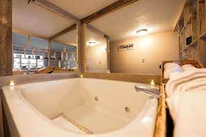 A large bathtub with wooden framing, a mirror, and a shelf with towels. - Smokies Romantic Retreat, 1BR/1BA, Private Hot Tub, 15min Walk to DT Gatlinburg (Gatlinburg)