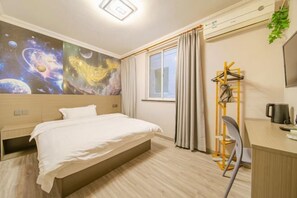 A hotel room with a bed, a desk, a chair, a coat rack, and a large wall mural. - Shanghai Evening Fenglin Hotel (Shanghai)