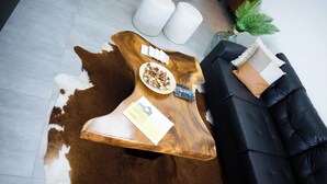 Une table basse en bois, une télécommande, un bol de collations et un magazine.