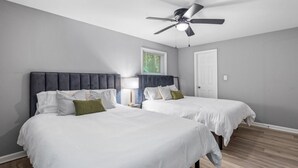 A bedroom with two beds, a ceiling fan, and a window with blinds. - 4BR 50-Acre Ridge Retreat | Nature & Fire Pit (Greensboro)