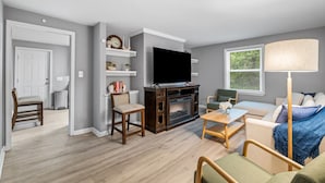 A modern living room with a fireplace, television, and seating area. - 4BR 50-Acre Ridge Retreat | Nature & Fire Pit (Greensboro)