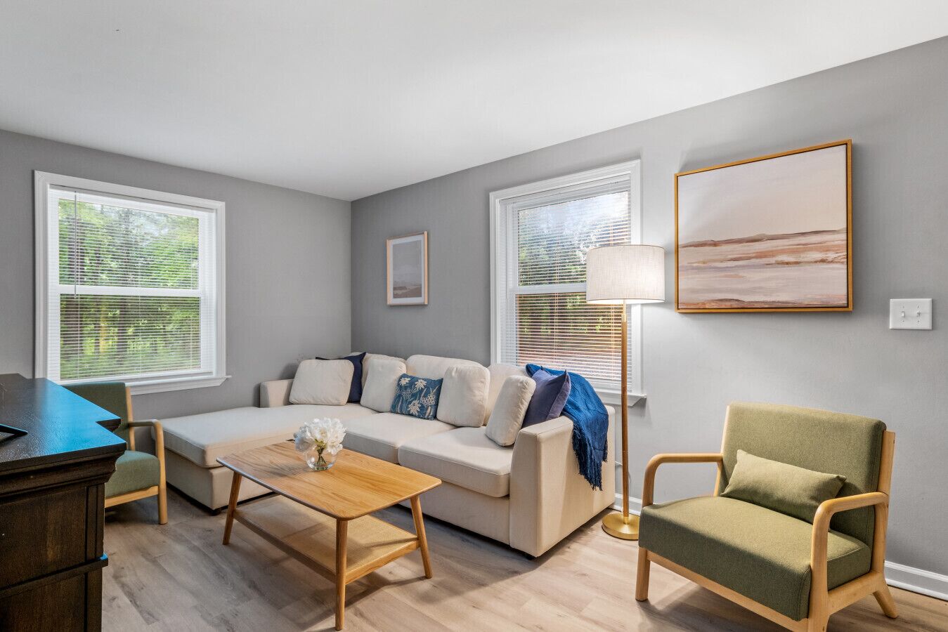 Un salon avec un canapé, une table basse, un fauteuil et une lampe.
