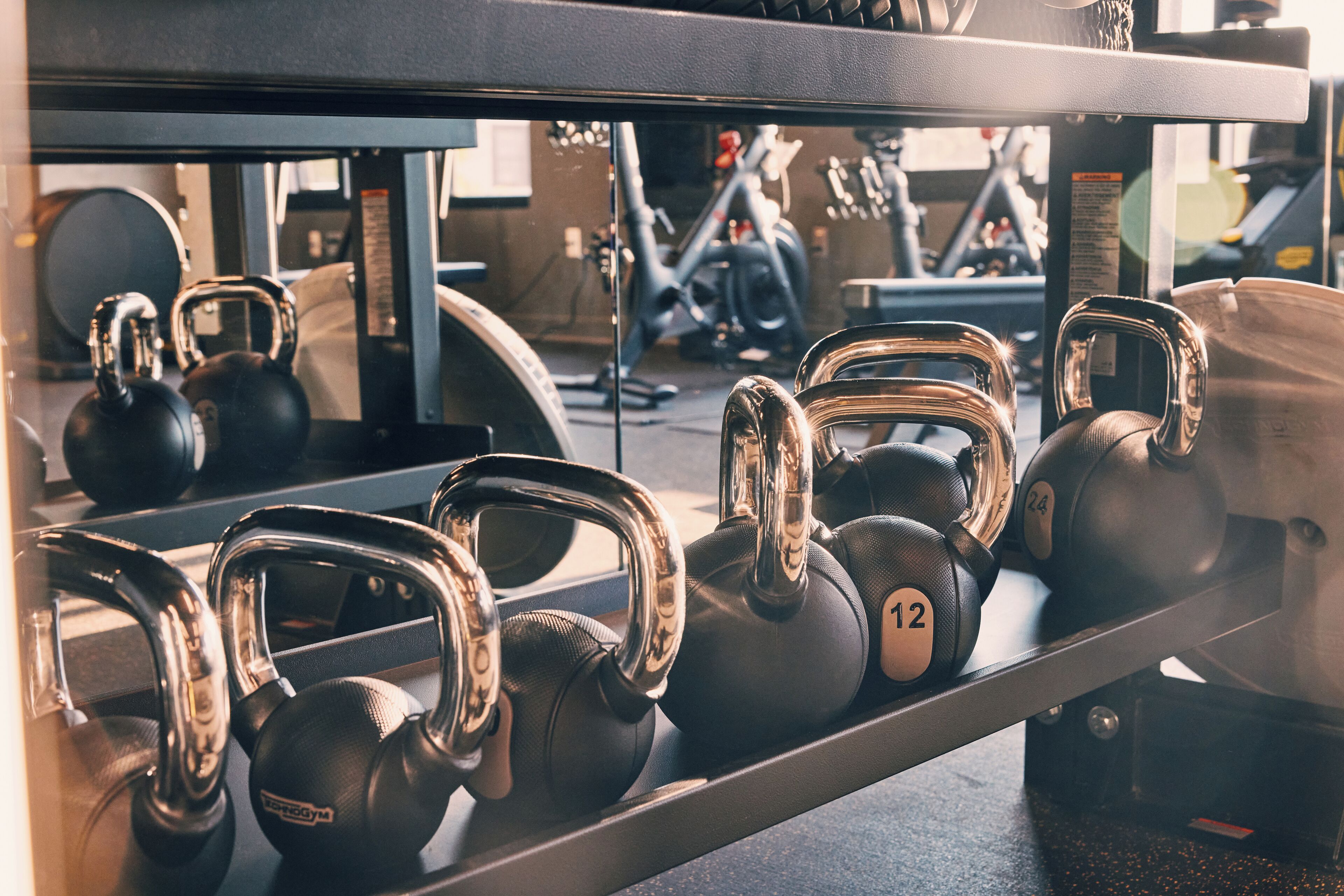 Eine Reihe von Kettlebells auf einem Gestell in einem Fitnessstudio.