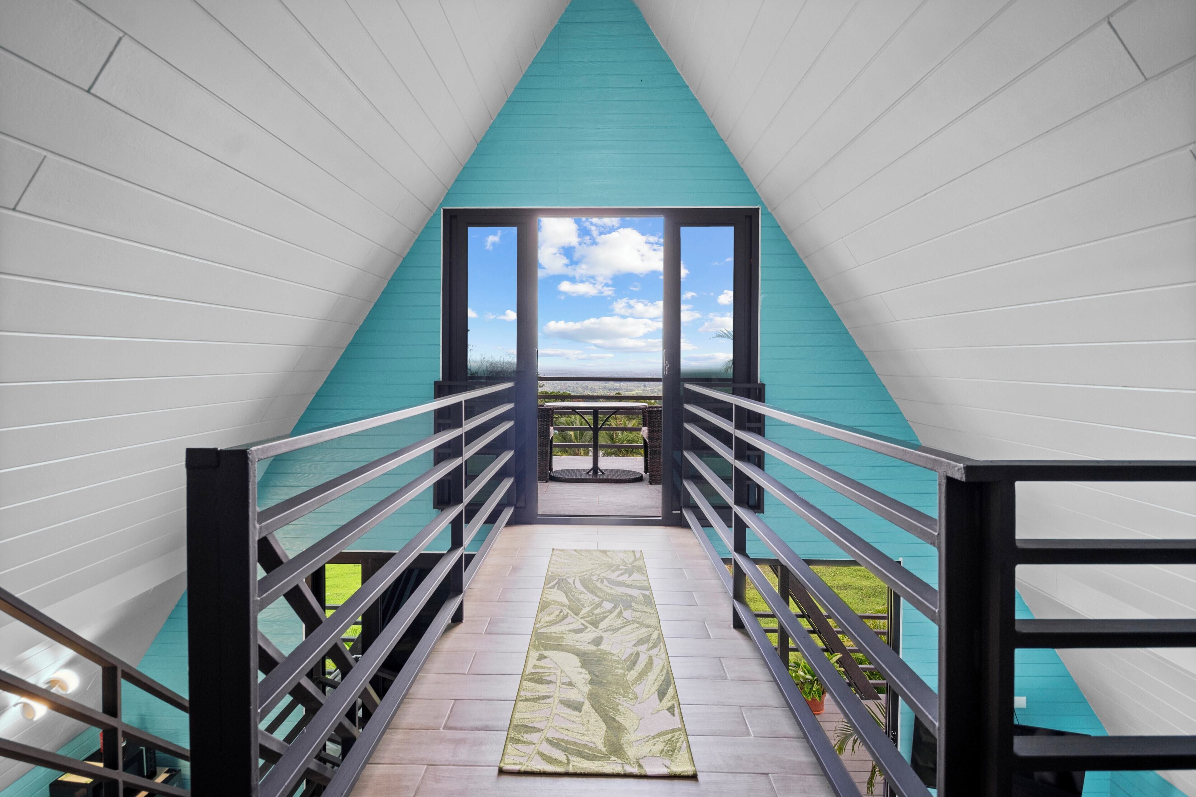 A staircase leading to a balcony with a view of the sky and clouds.
