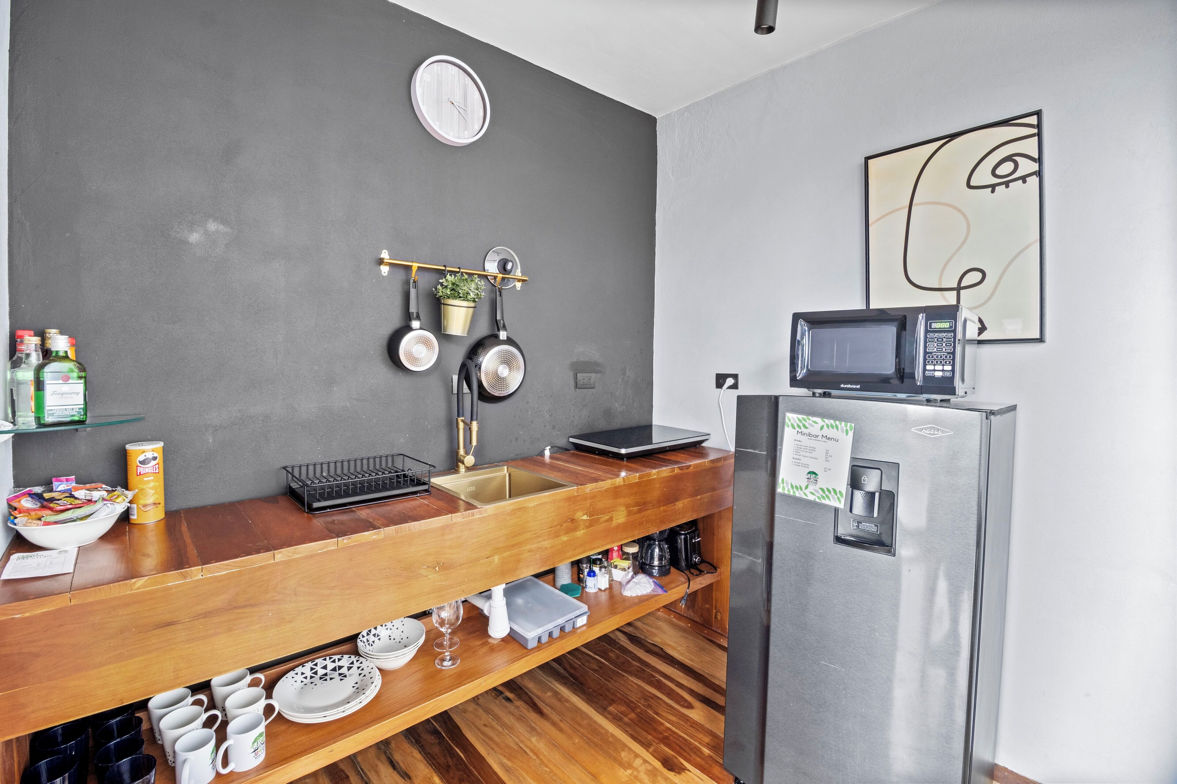 Une cuisine moderne dotée d’un plan de travail en bois, d’appareils électroménagers en acier inoxydable et d’un design minimaliste.