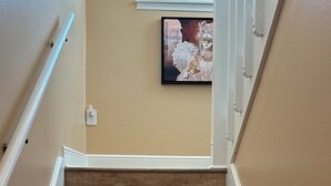 A wooden staircase with white railings, a framed picture on the wall, and a window at the top. - Immaculate 3 bedroom villa: updated amenities on the Prestigious IMG Golf Course (Bradenton)