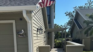 A house with a stone patio, a bird sculpture, and an American flag. - Immaculate 3 bedroom villa: updated amenities on the Prestigious IMG Golf Course (Bradenton)