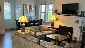 A living room with a sectional sofa, two lamps, a flat-screen TV, and a fireplace. - Charming 1-bed/2 bath Cottage WiFi,AC, Beach, Pool, Fireplace
Pool Table, Ping (South Haven)