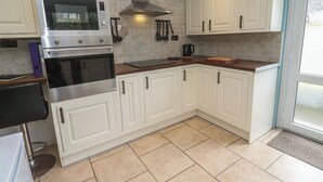 A kitchen with white cabinets, a stainless steel oven, a microwave, and a gas stove.