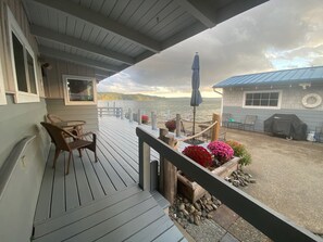 Eine Holzterrasse mit Sitzgelegenheiten und Blick auf einen See.