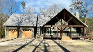 A two-story house with a garage, a covered porch, and a chimney. - Spacious Cabin on Little Mo River!! Game Room! Relax & Have Fun! 4 Bed, 4.5 Bath (Murfreesboro)