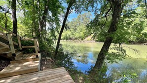 A wooden deck leading to a calm lake surrounded by trees. - Spacious Cabin on Little Mo River!! Game Room! Relax & Have Fun! 4 Bed, 4.5 Bath (Murfreesboro)
