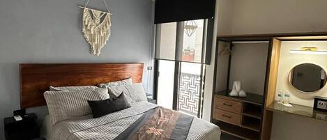 Quarto moderno com uma cama grande, cabeceira de madeira, penteadeira com espelho e guarda-roupa.