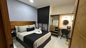 A bedroom with a bed, a desk, a chair, and a wardrobe. - Hotel Palenque Premier (Palenque)