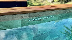A pool with a wooden deck and a name plaque reading "SANTA MARIA". - Gîte Santa Maria (Grand-Bourg)