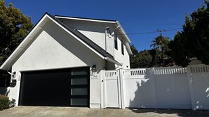 A modern two-story house with a garage, a white picket fence, and a clear blue sky. -  Deluxe Guest Suite with Private Entrance, Near San Diego Beaches, Sleeps 4 (San Diego)