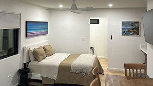 A bedroom with a bed, a ceiling fan, a painting, a TV, and a wooden table. -  Deluxe Guest Suite with Private Entrance, Near San Diego Beaches, Sleeps 4 (San Diego)