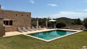 A stone building with a swimming pool, lounge chairs, and a grassy area. - Country House 'Son Gener' with Private Pool, Private Terrace and Wi-Fi (Son Servera)