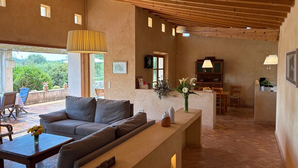 A spacious living area with a sofa, a coffee table, and a dining area with chairs. - Country House 'Son Gener' with Private Pool, Private Terrace and Wi-Fi (Son Servera)