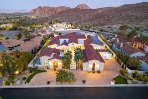 A large, multi-story residential building with a courtyard, surrounded by desert landscape and mountains. - Poolside Oasis, Golf Paradise, Hot Tub, Spa, Views (La Quinta)