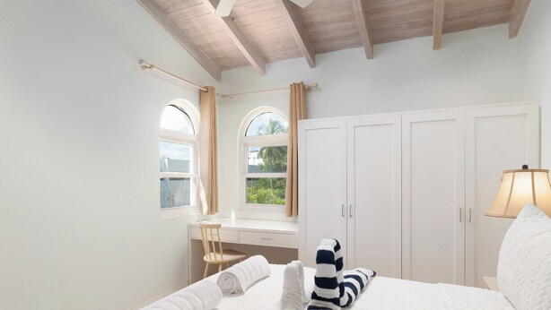 A bedroom with a bed, a desk, and a chair.