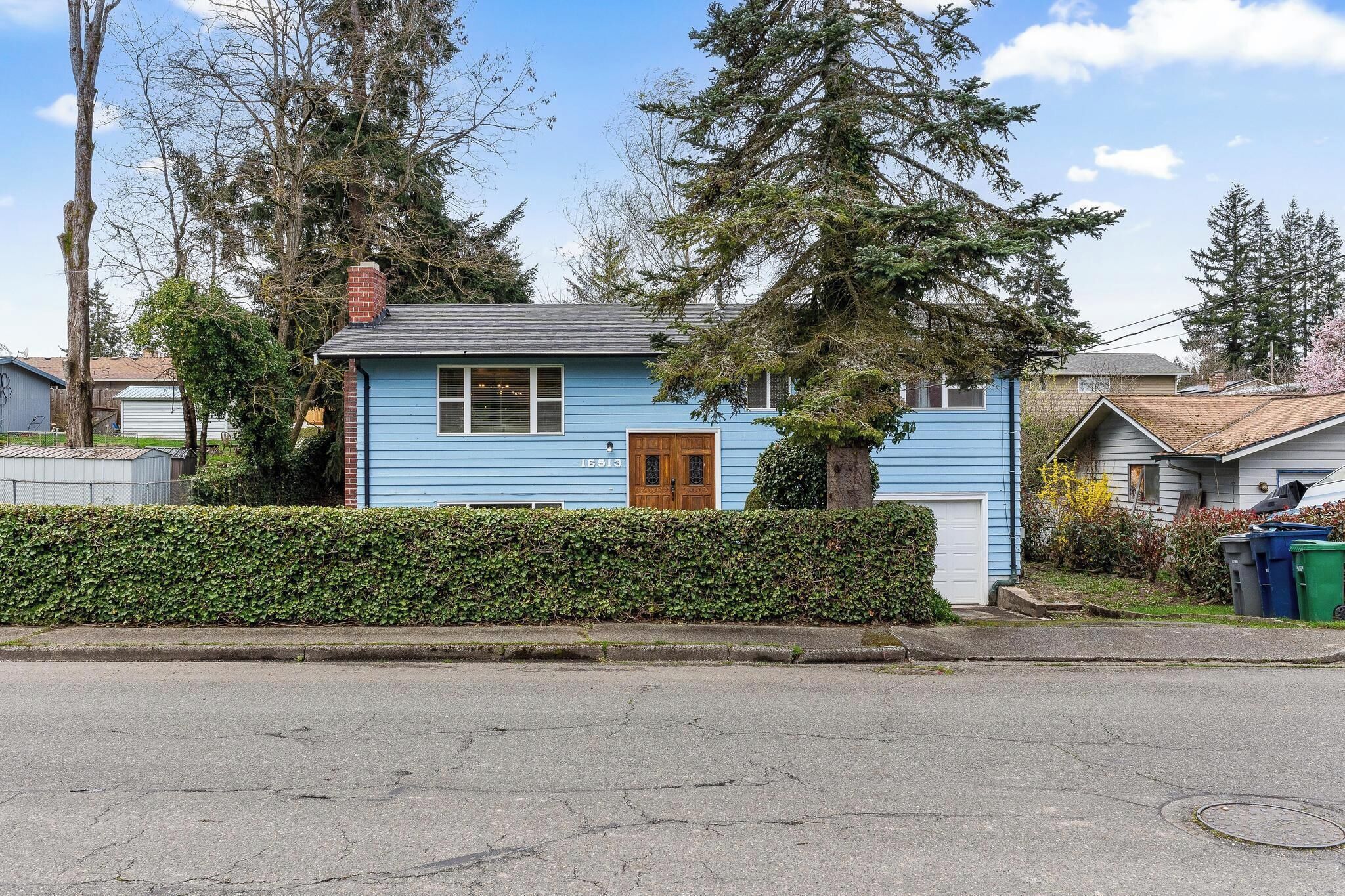 A single-story house with a blue exterior, a front door, and a small porch.