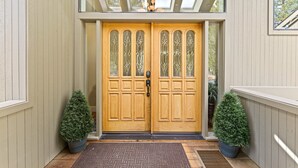 A wooden double door with glass panels and a keypad lock, flanked by potted plants, leading to a covered entrance with a skylight above. - 20 Aspen - Elegant & Updated & Perfect for Family! SHARC, Hot Tub (Bend)