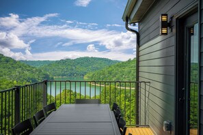A balcony with a table and chairs overlooking a lake and forested hills. - Modern Center Hill Lake Home, Fall Lake Views + Fire Pit (Smithville)
