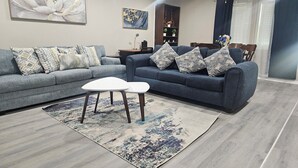 Een moderne woonkamer met twee banken, een bijzettafeltje en een vloerkleed.