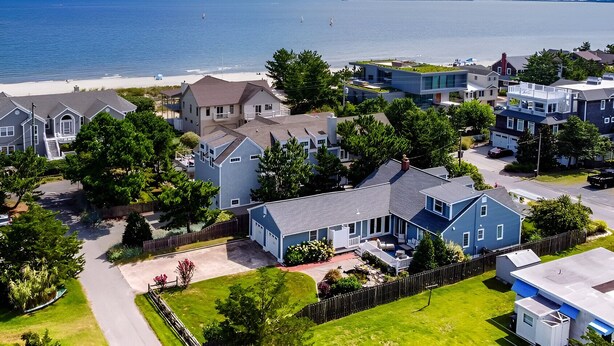 A residential area with houses, a beach, and a clear view of the ocean. - Cape Cod Charm -- Steps From Beach, 3 King Beds, Beach Equipment & Linens (Lewes)