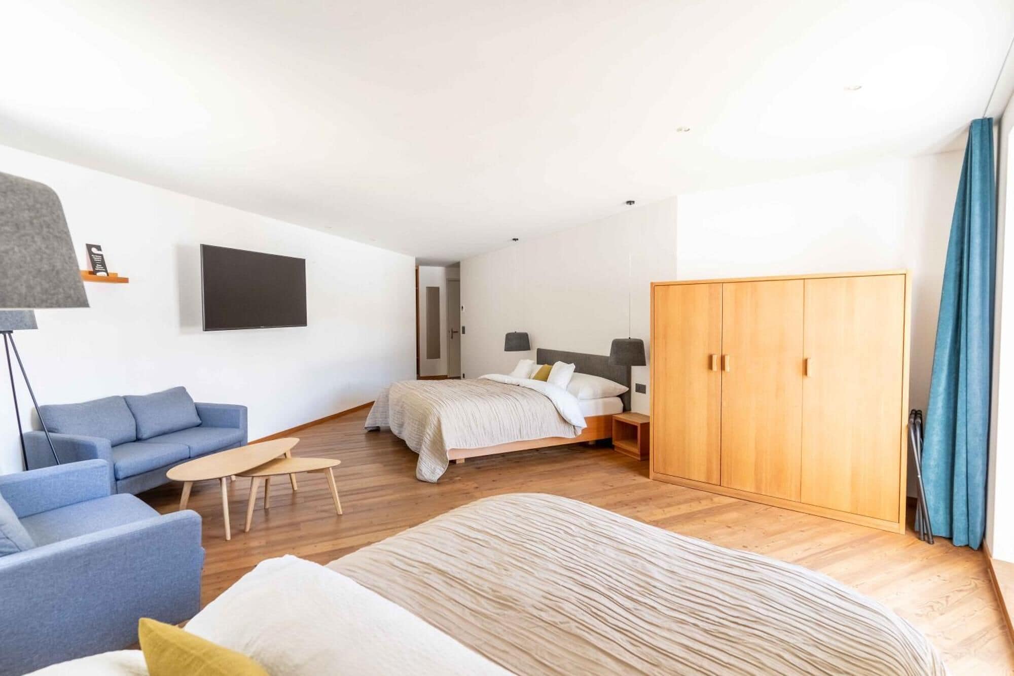 Une chambre d’hôtel moderne équipée d’un lit, d’un canapé, d’un bureau et d’une armoire.