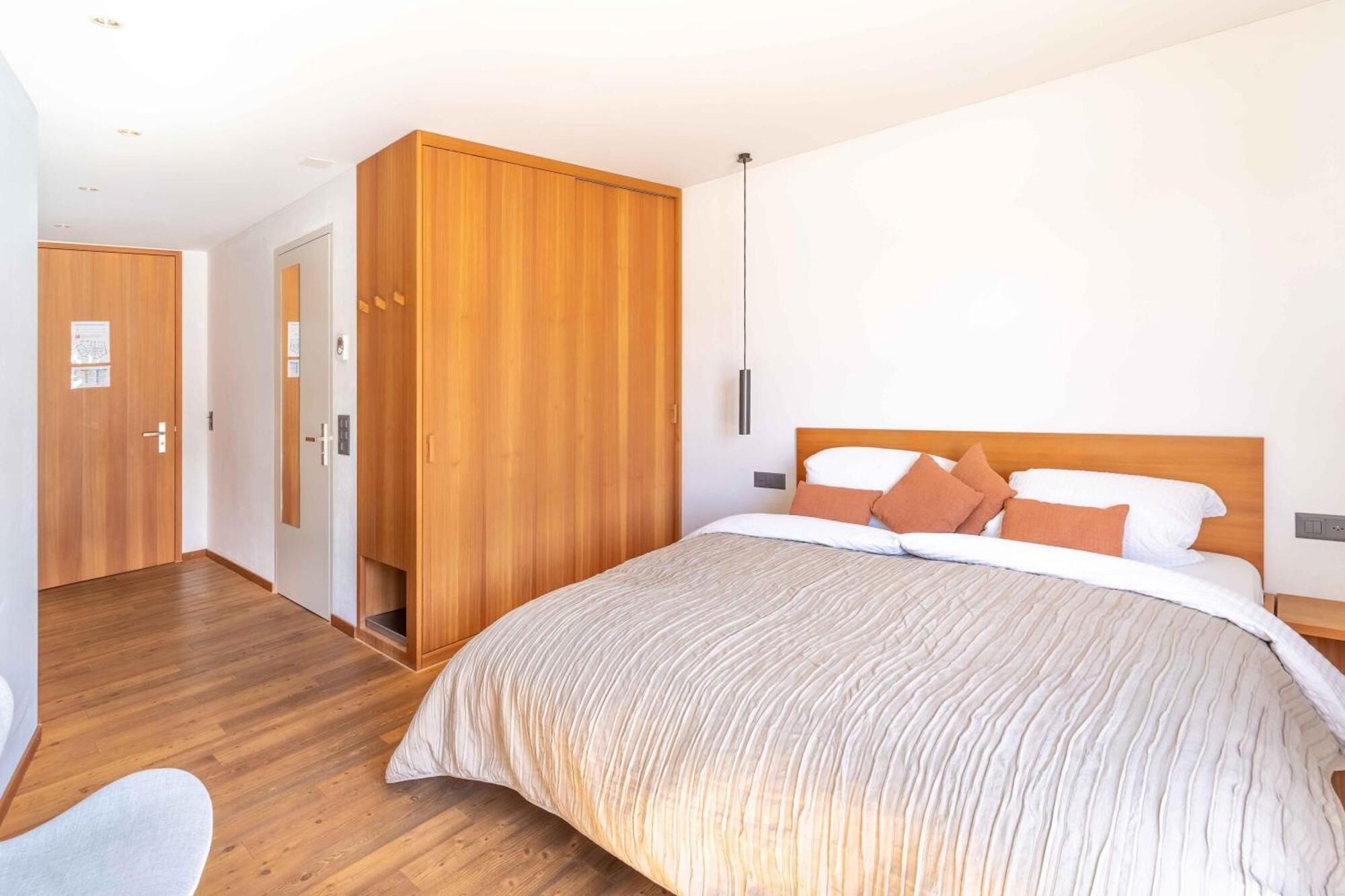 Un dormitorio con una cama grande, un armario de madera y una puerta con un mapa.