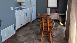 A compact kitchen with white cabinets, a wooden dining table, and a ceiling fan. - The Most Beautiful Views in Turner Falls (Davis)