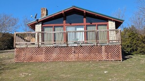 A cabin with a wooden deck, a stone chimney, and a sign indicating it is cabin number 5. - The Most Beautiful Views in Turner Falls (Davis)