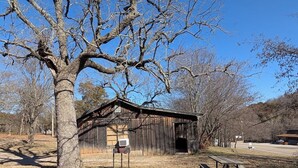 A rustic wooden building with a small porch and a sign in front.